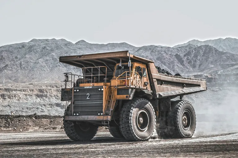 Caterpillar haul truck on a dusty quarry road