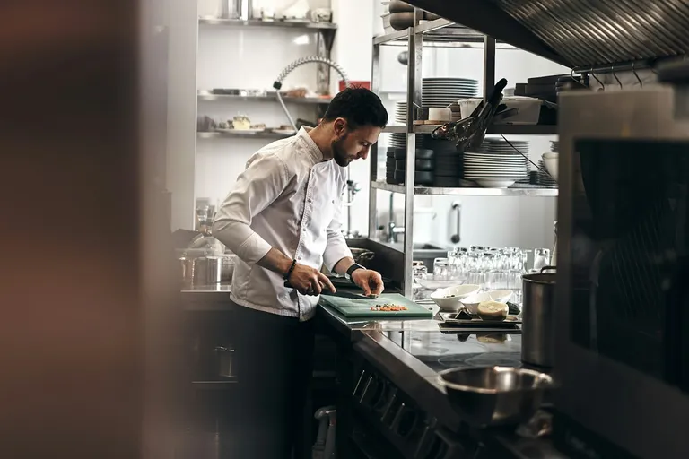 Chef chopping vegetables in a restaurant kitchen