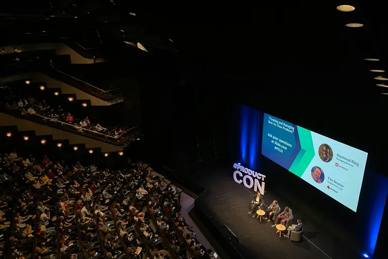 Panel discussion on stage in a large auditorium