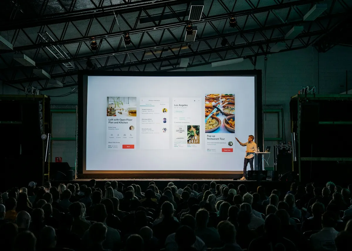 Presenter in front of a large screen at a conference