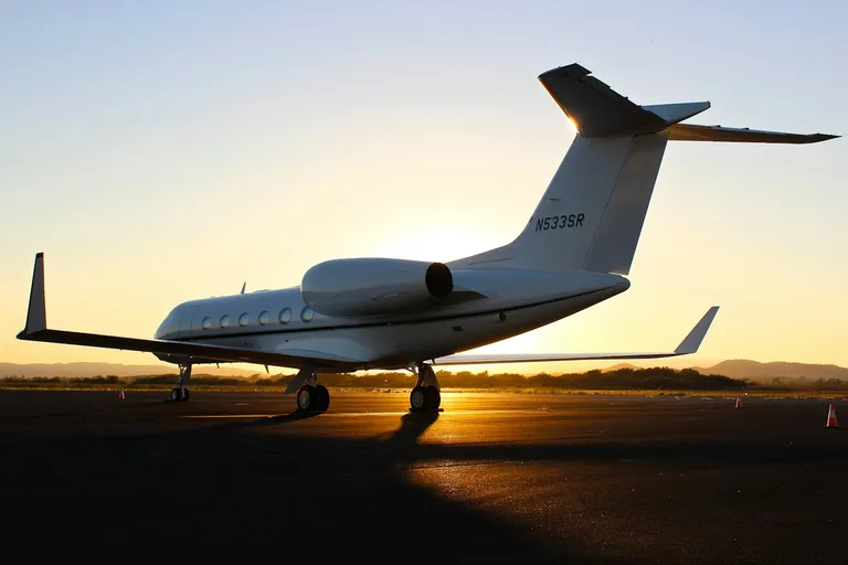 Private jet on an airport tarmac at golden hour