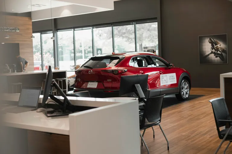Red car parked in a dealership showroom