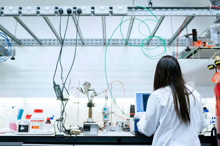Scientist in a lab coat using a laptop in a laboratory