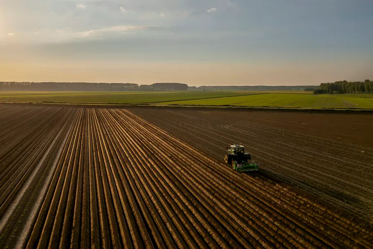 Tractor plowing a field at sunset