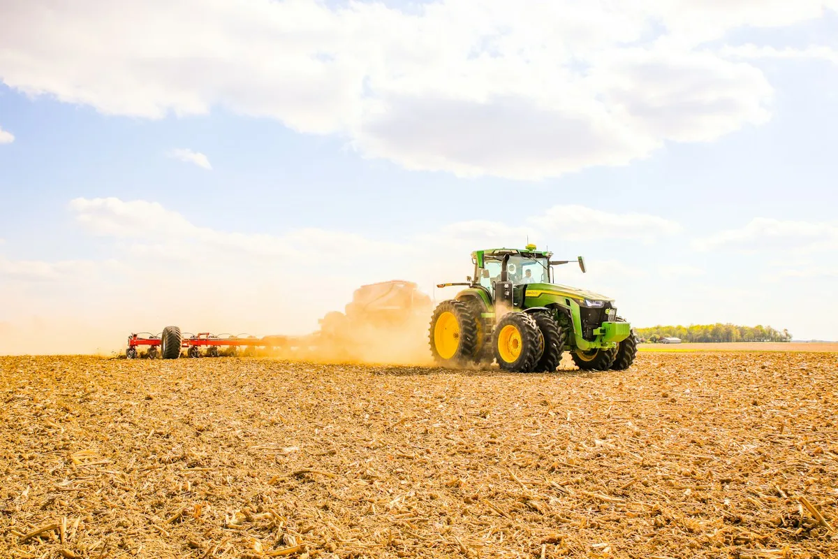 Tractor plowing a field with a trailer