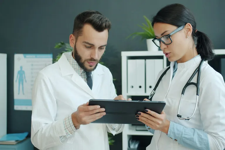 Two doctors looking at a tablet together