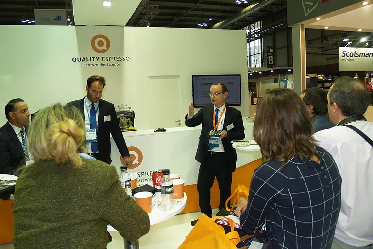 Visitors and exhibitors talking at a hospitality and foodservice equipment trade fair stand