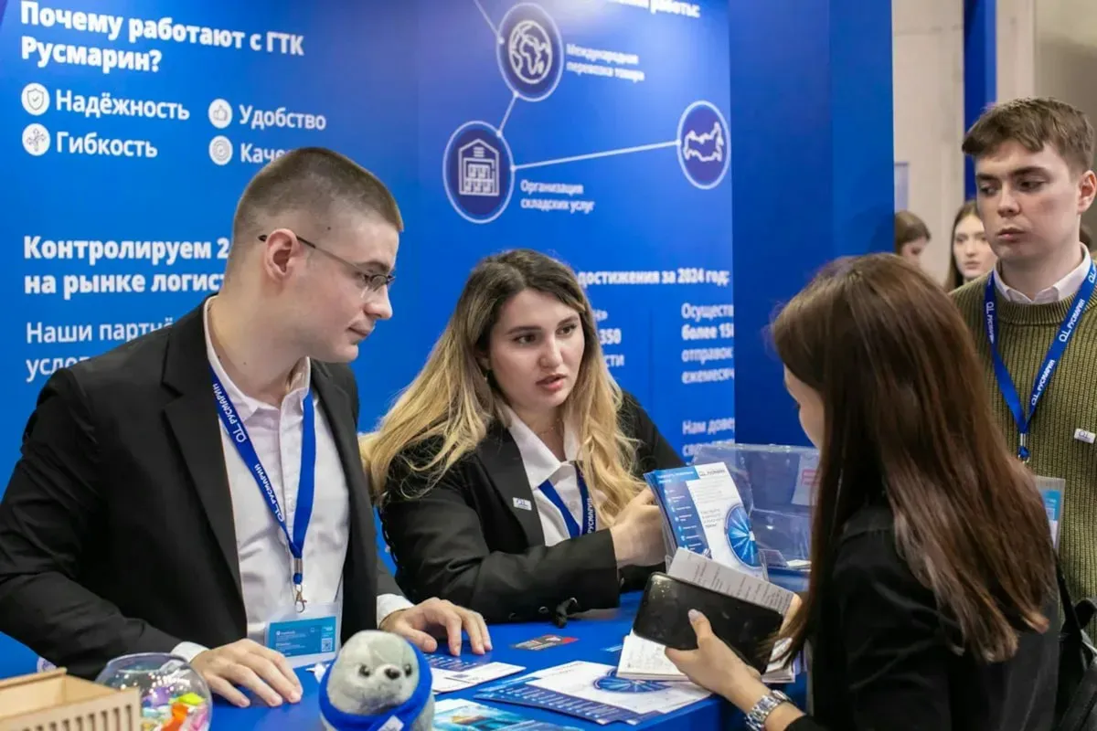 Visitors at a business exhibition talking at a booth
