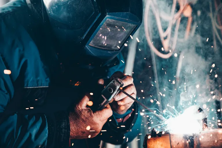 Welder at work with a welding machine