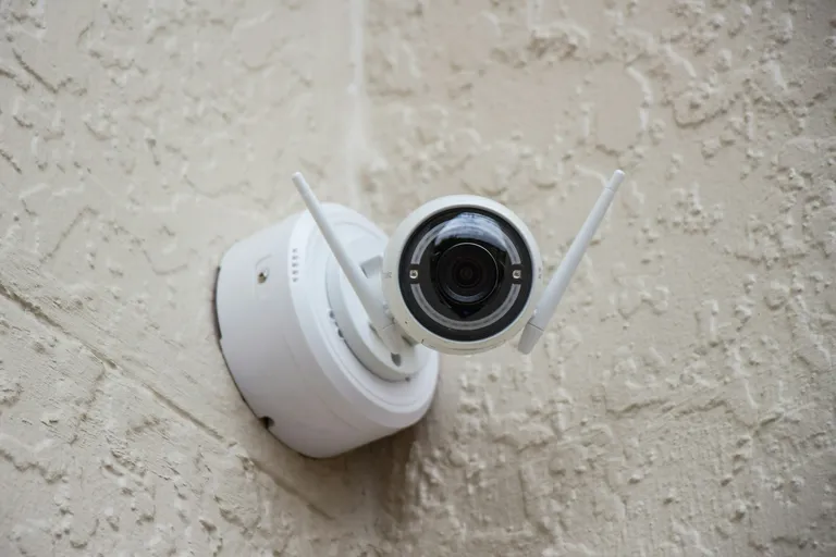 White surveillance camera on a wall