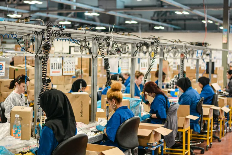 Workers at an assembly line in a large factory